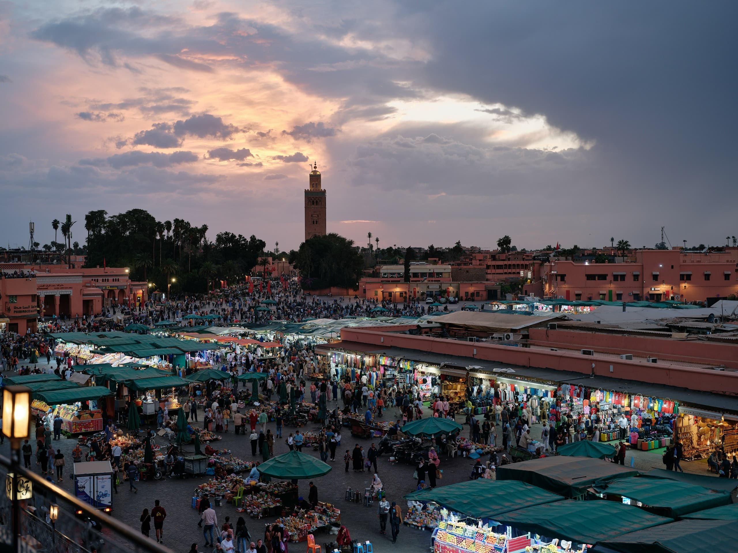Jemaa el-Fnaa at dusk, food stalls lit under the Koutoubia minaret
