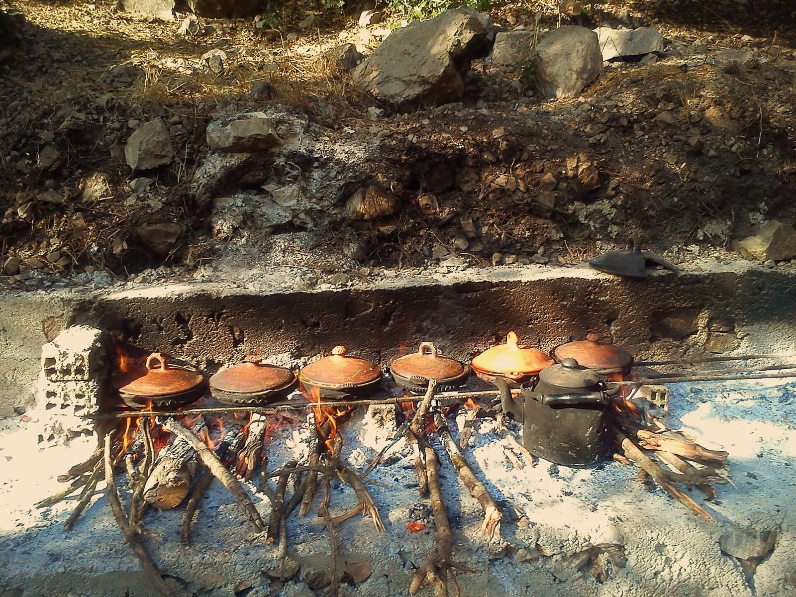 Clay tagines cooking over an open fire