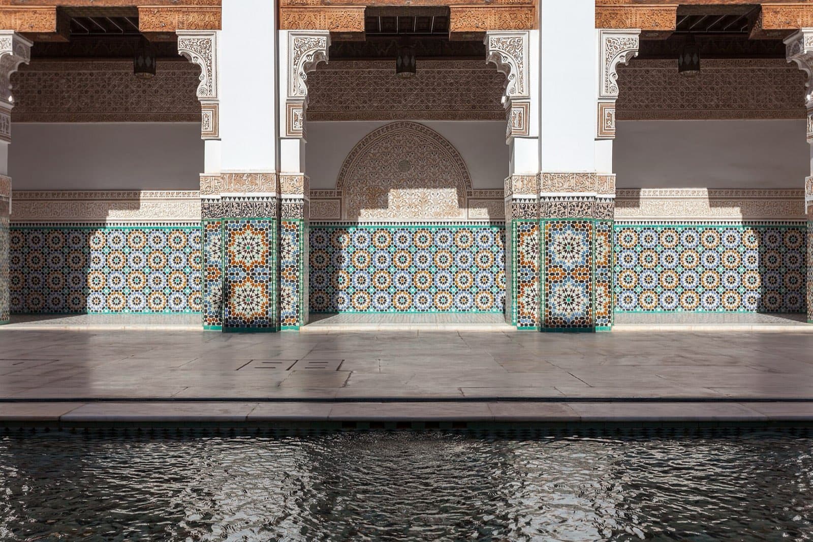 Carved stucco and cedar around the courtyard pool of the Ben Youssef Madrasa